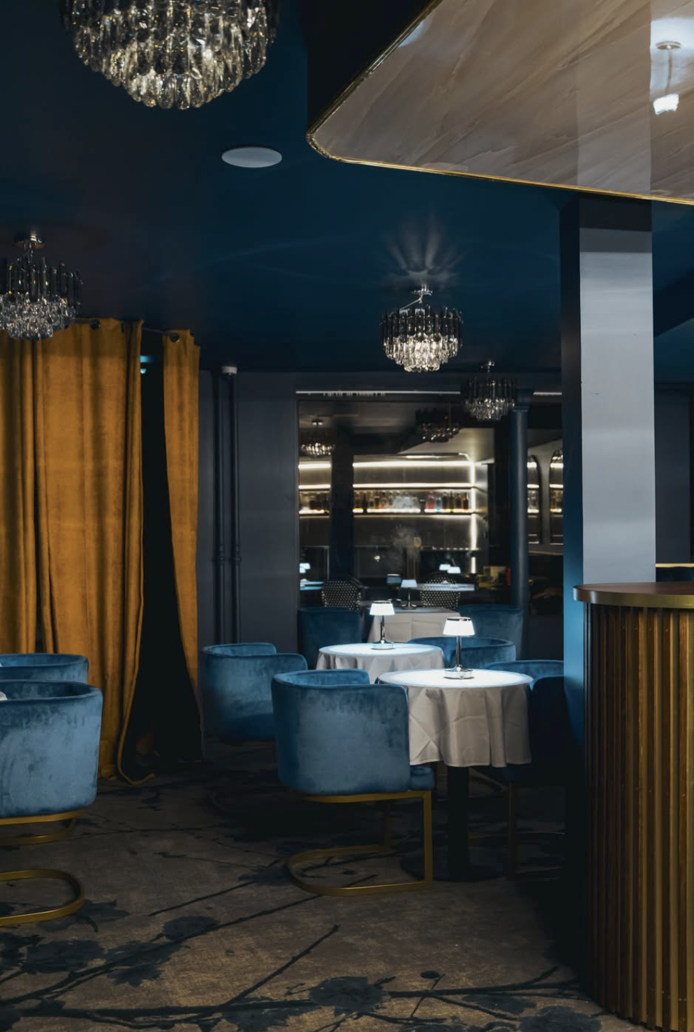 Salle du restaurant Panthera, fauteuils en velours bleu et lustres